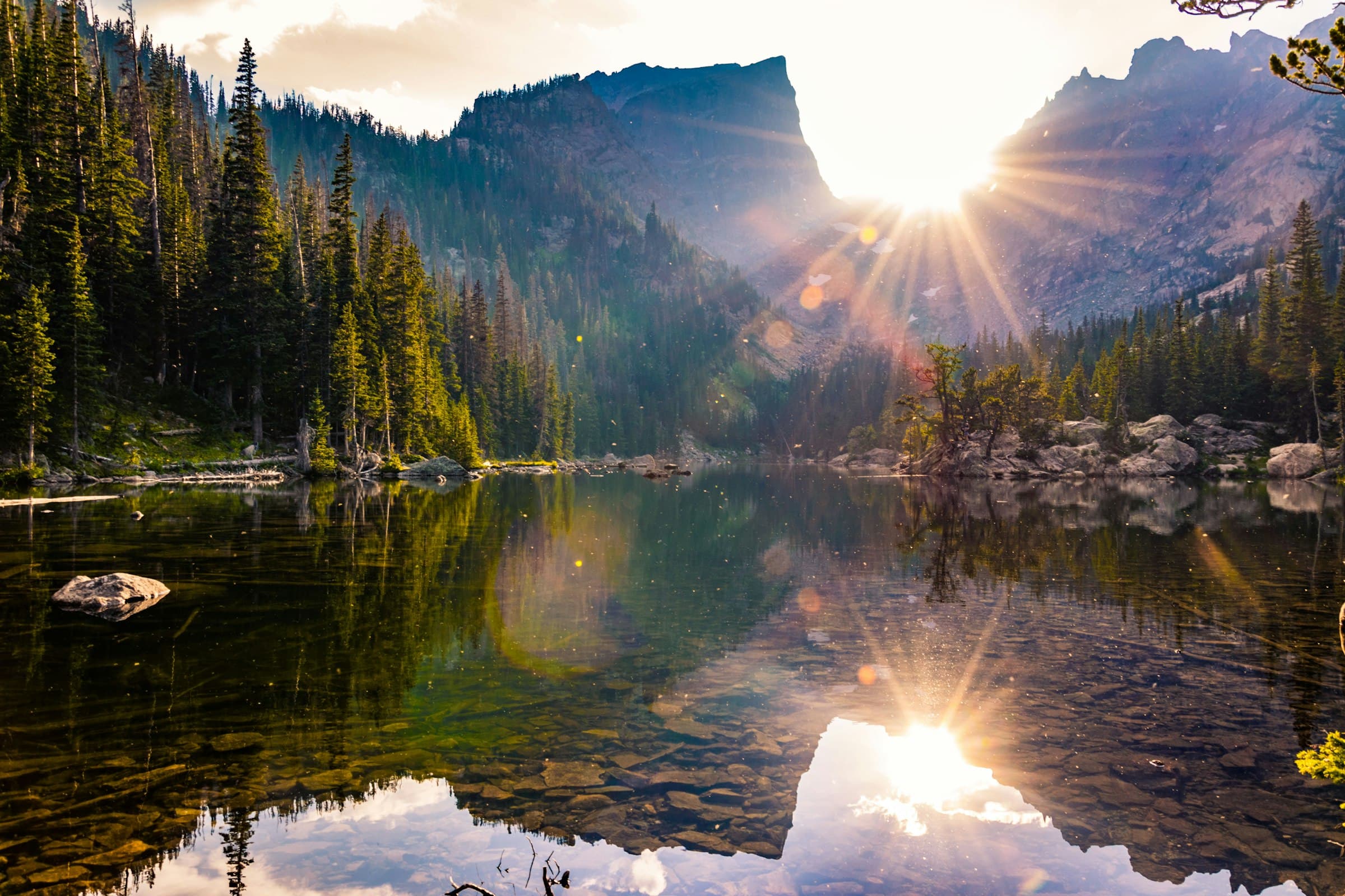 A calm alpine lake in Rocky Mountain National Park at dawn